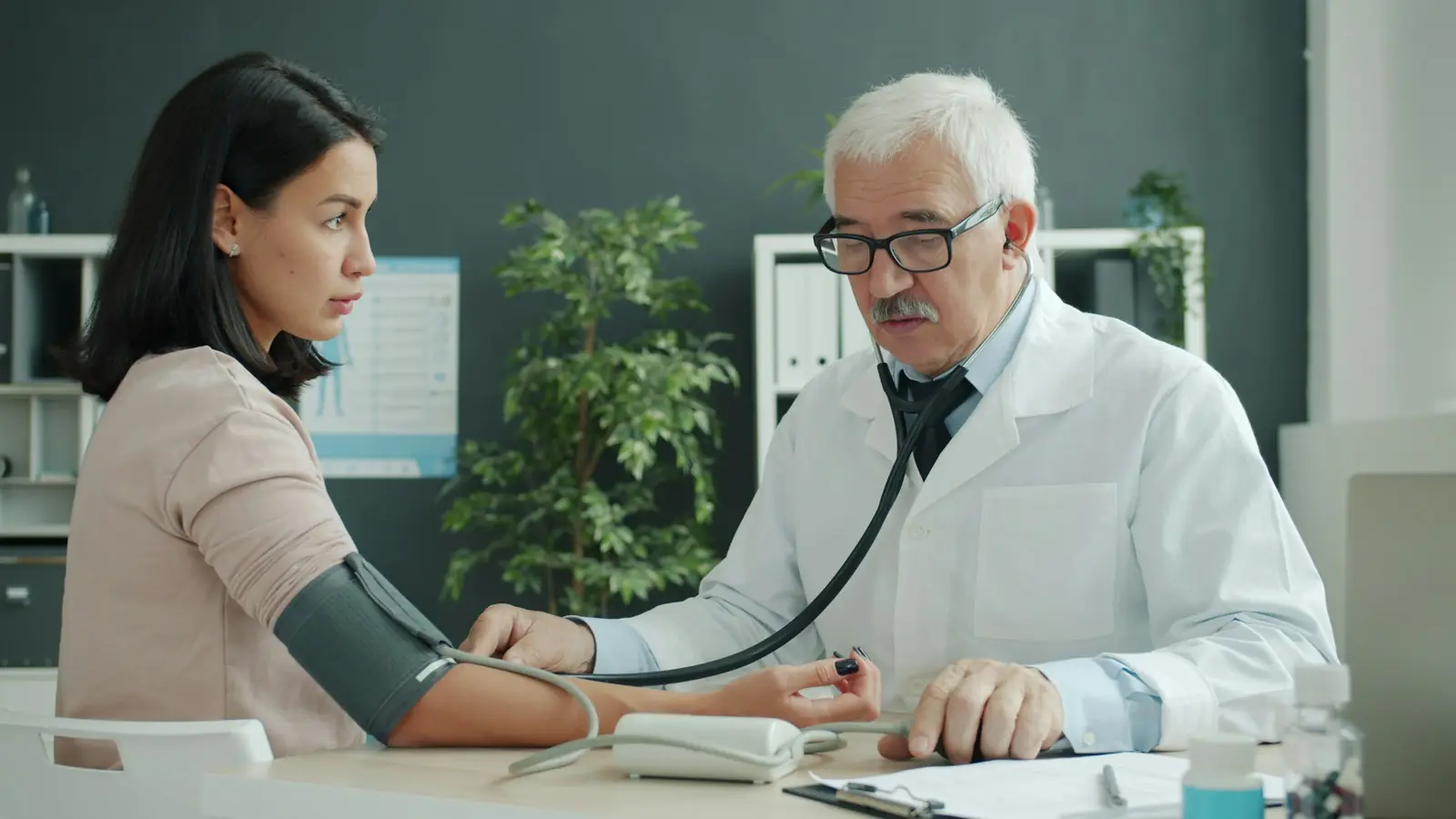 A doctor taking a patient’s blood pressure in a consulting room