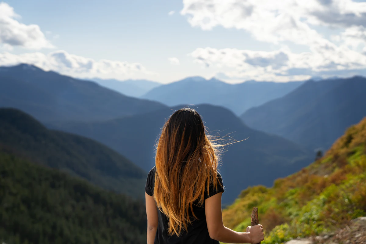 A woman looking out over a green mountain valley
